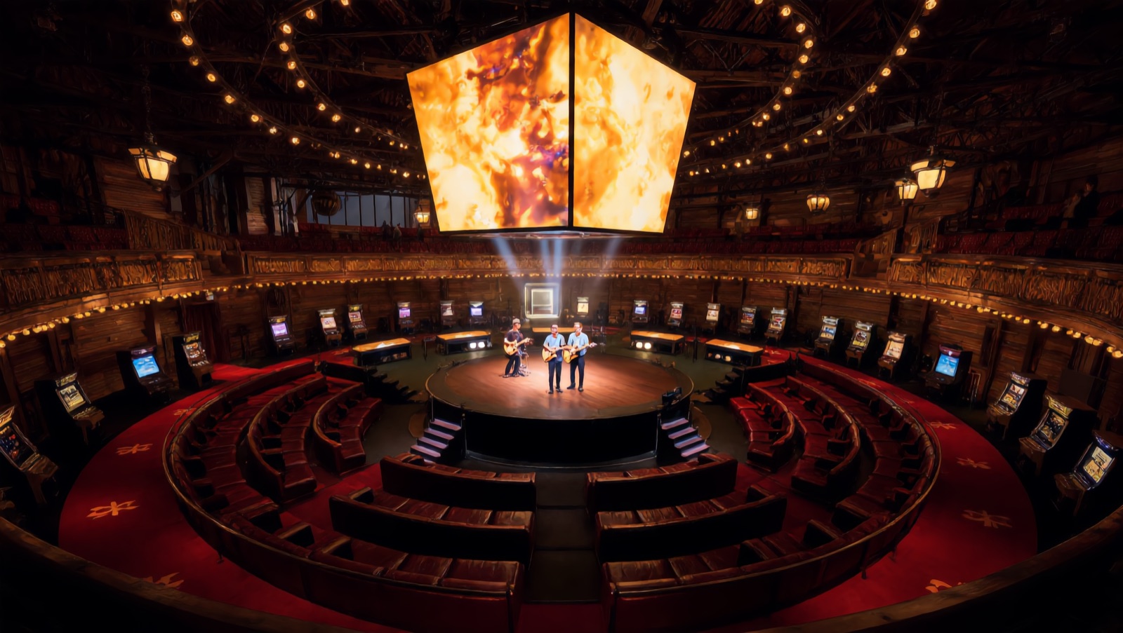 Concept render — a live band on the round center stage beneath the hanging four-sided jumbotron, lounge tiers and machine rings wrapping the warm timber hall