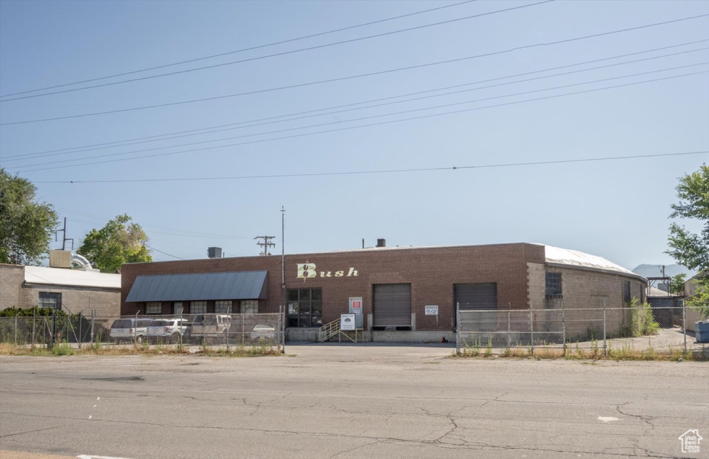 Street view of the real 827 S 500 W property — single-story brick warehouse behind its fence